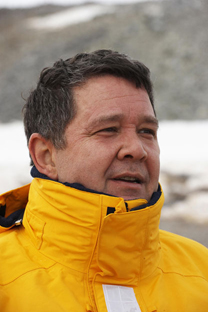 Author Frank Viva in a yellow coat in front of a snowy background