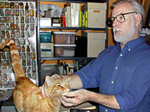 Author Jay Lynch poses for the camera as he pets an orange cat