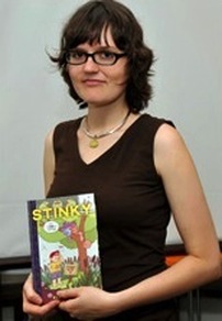 Author Eleanor Davis poses for the camera, holding a copy of Stinky