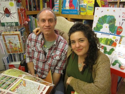 Authors Nadja Spiegelman and Trade Loeffler pose together in a room crowded with children's books