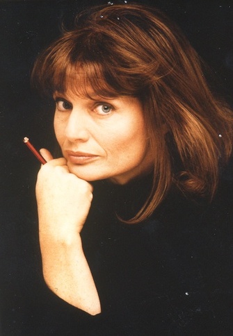 Author Agnès Rosenstiehl holds a red pen as she poses in front of a dark and moody background