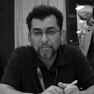 Author Jaime Hernandez poses for the camera in a grey-scale photo